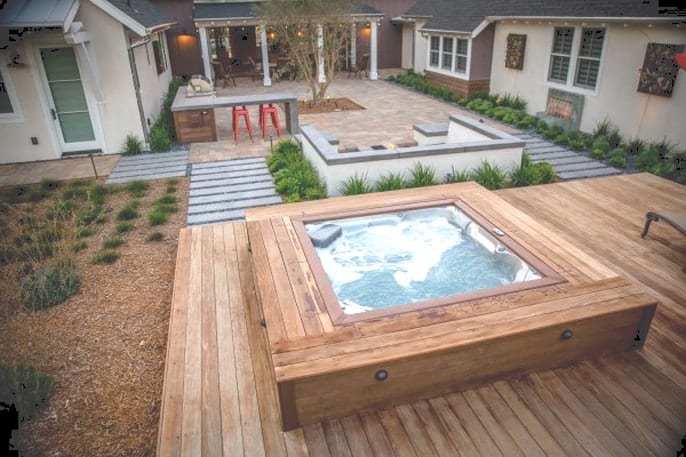 A hot tub with natural wooden decking that complements any garden setting