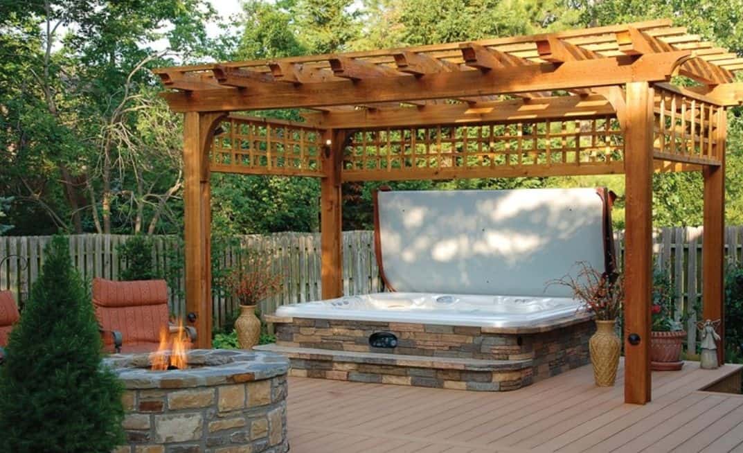 An outdoor hot tub with pergola for added shade and privacy
