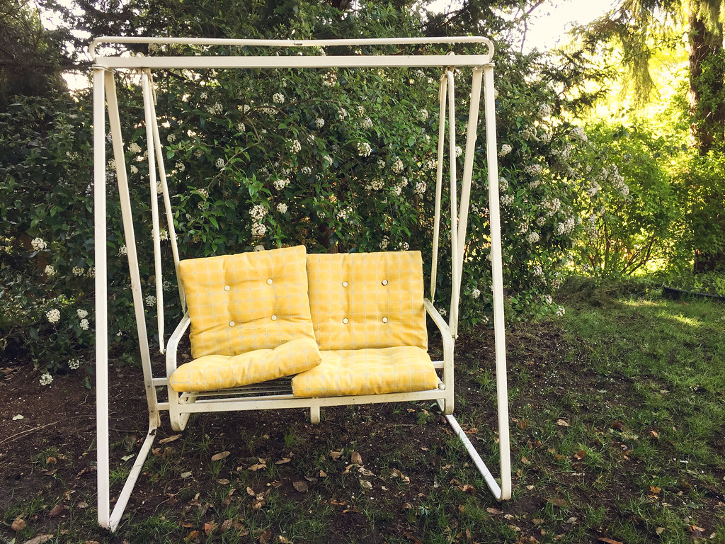 Corner garden swing with yellow cushions