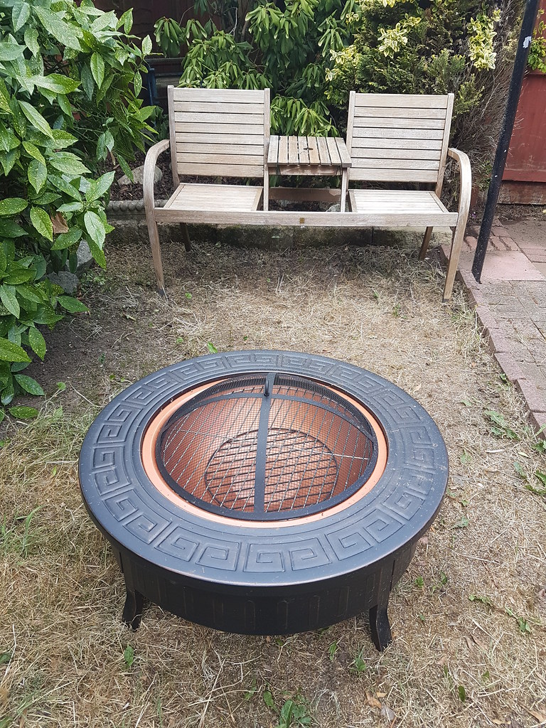 Small circular-shaped fire pit with love-seat bench in front