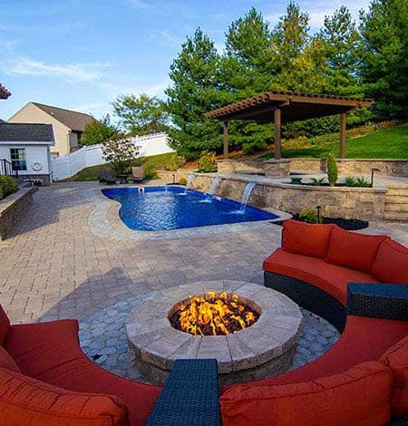 A fire pit near to a swimming pool