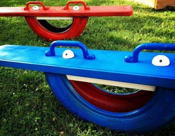 Blue and red DIY tyre seesaw with faces