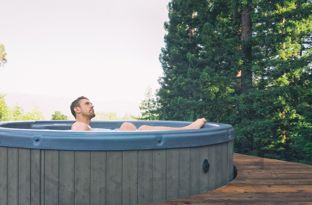 A man on a hot tub with a view of the nature