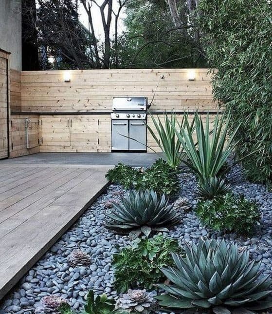 Deserted-style garden with wood decking, stone beds and succulents