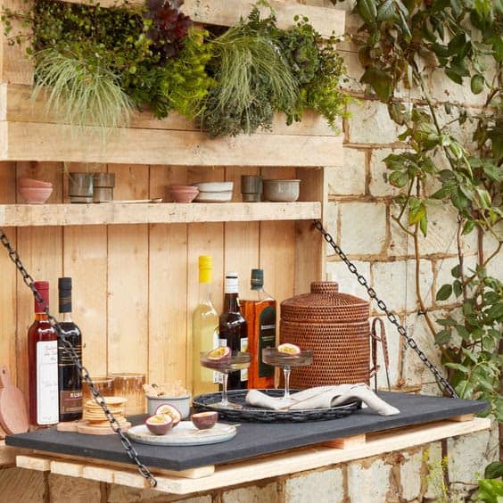 A side garden bar that features built-in planter for decoration and a sturdy table top for eating and drinking