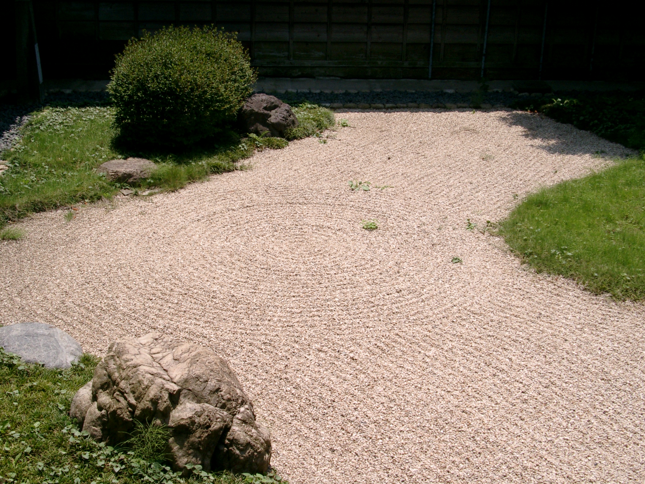 Small zen garden with white sand and gravel.