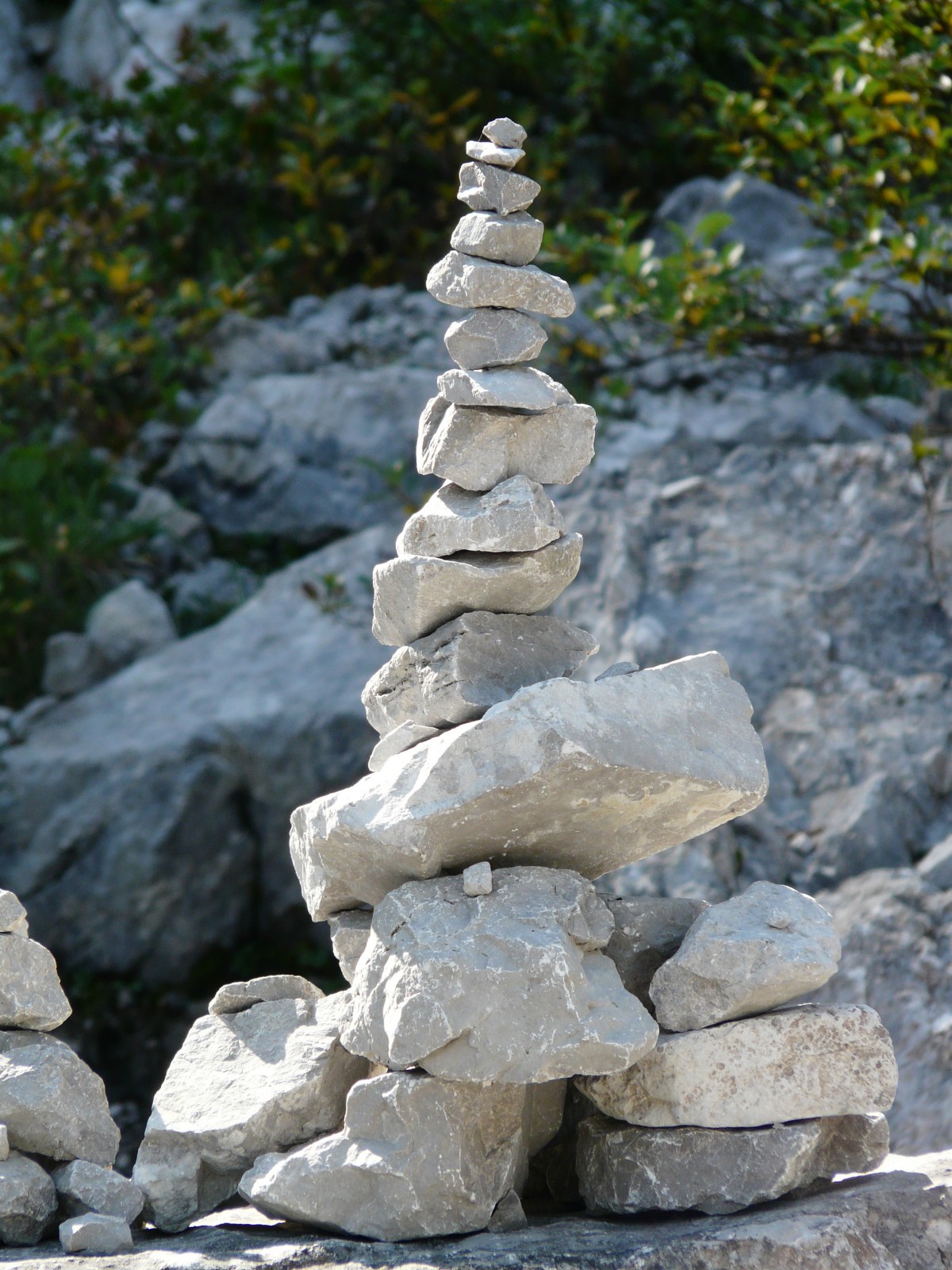 A rock sculpture positioned on a big flat rock.