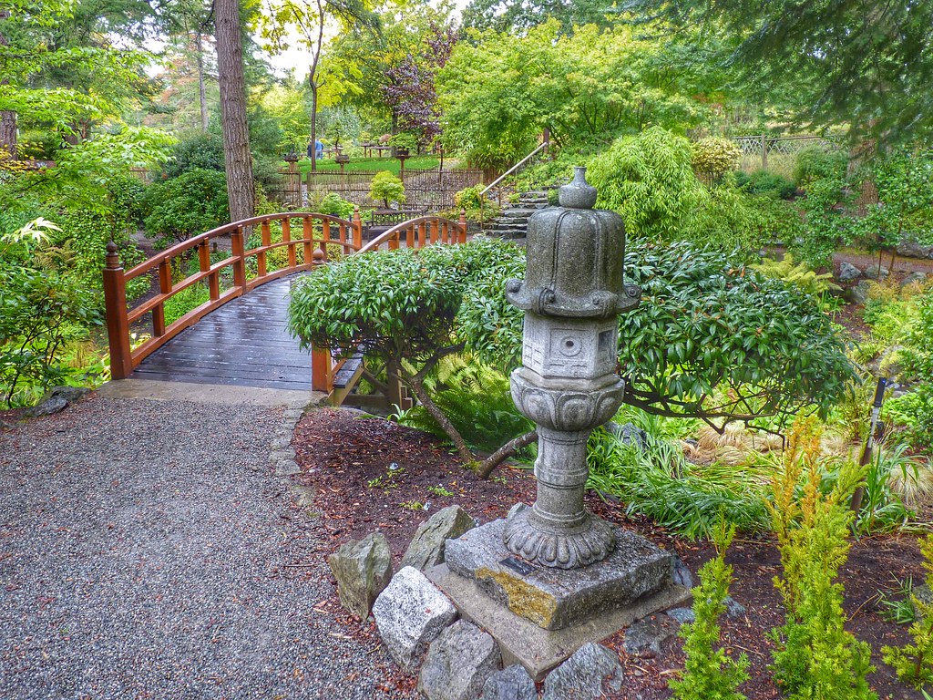 A Zen garden entrance with connecting red bridge.