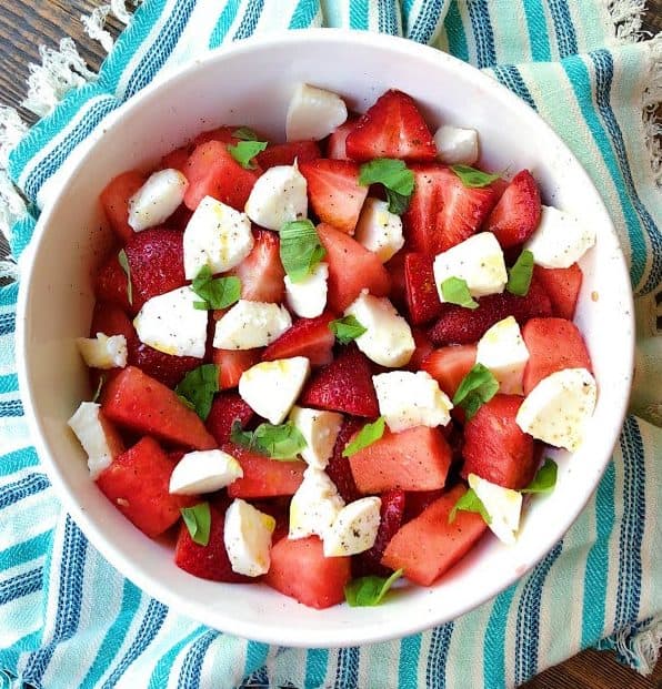 Strawberry and watermelon caprese salad in a white bowl