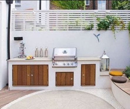 Small white BBQ area with wooden cabinets