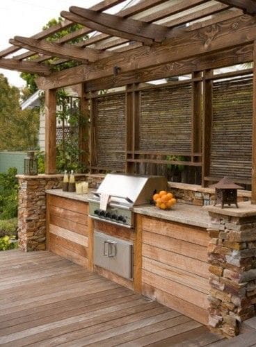 Rustic BBQ area made from weathered wood panels and stone walls