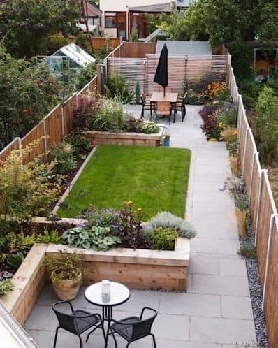 Narrow garden with grass with raised flower beds