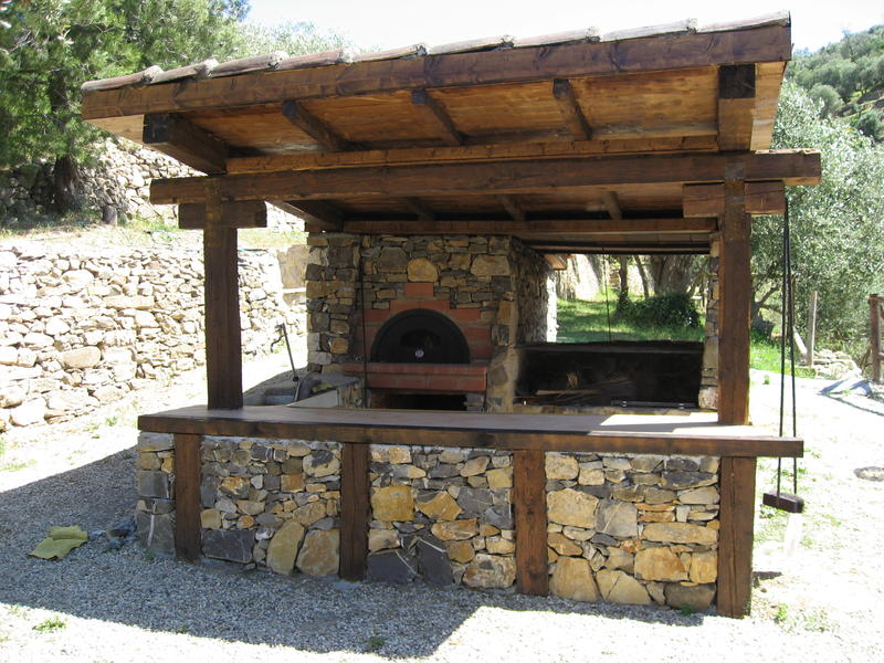Rustic BBQ area with logs and stones