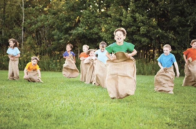 Kids having fun while playing potato sack race