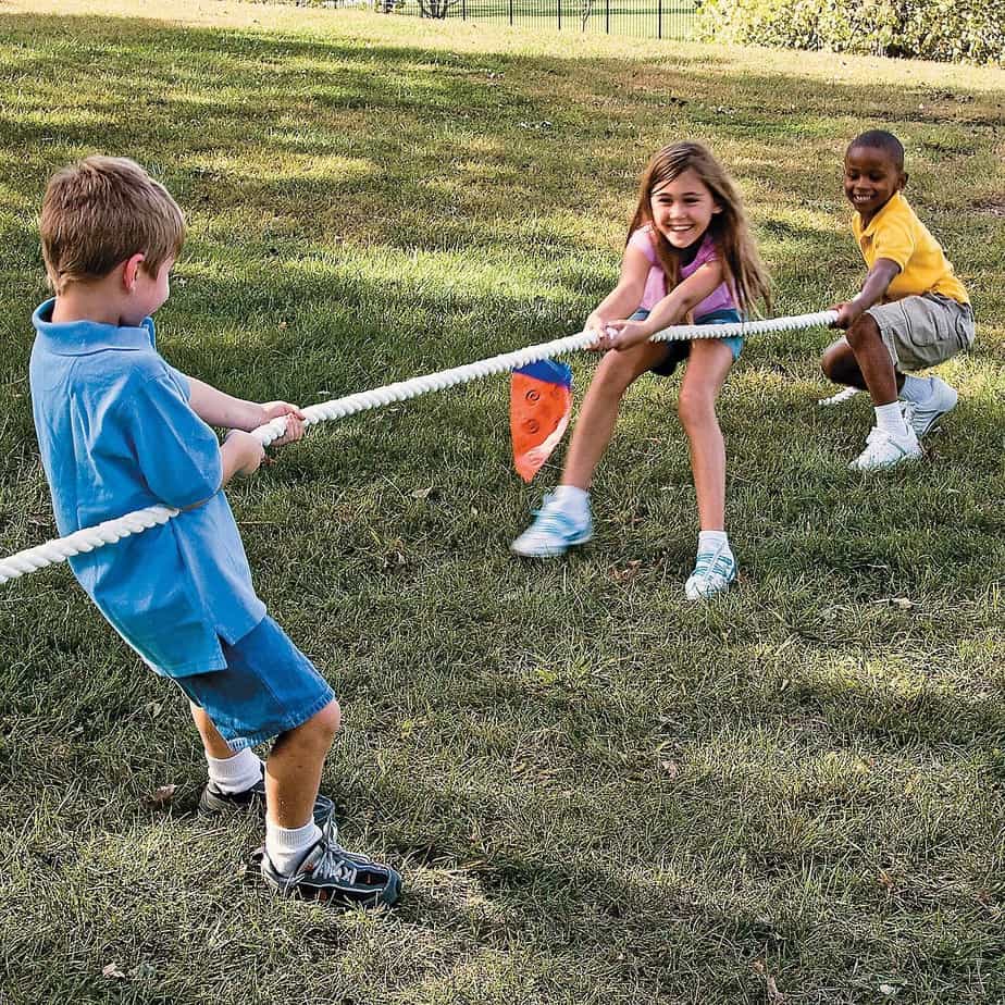 Children playing tug of war in the backyard