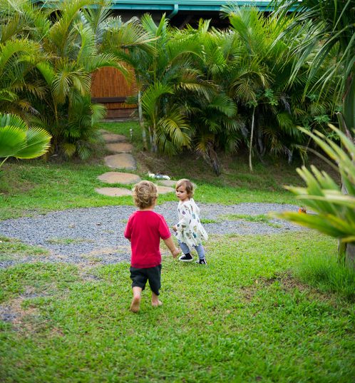Two little child running in their garden play meadow