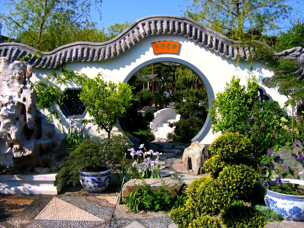 Lush Chinese garden with moon gate entrance