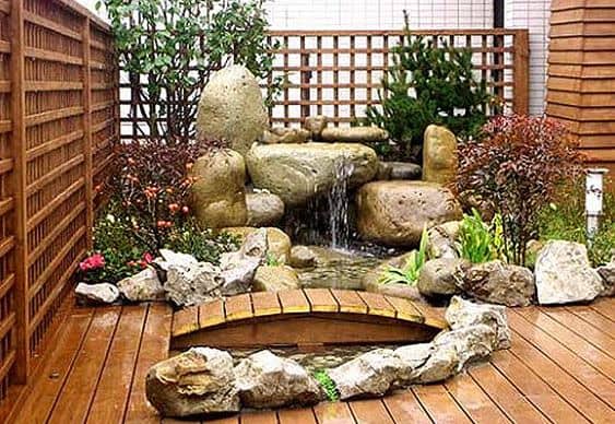 Bridge on wooden deck with a dramatic stone water feature