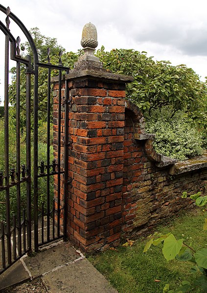 Iron gate with red brick wall