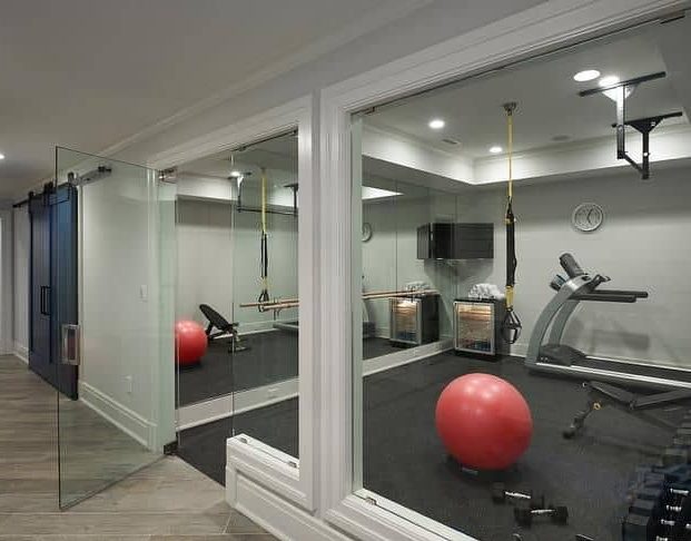 A combination of mirrors and glasses separating the rooms in a garden gym