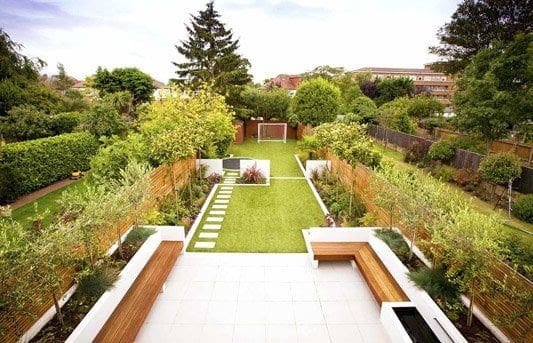 Long narrow open garden with some garden beds and stepping stones