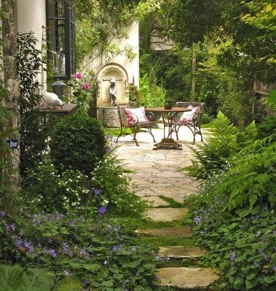 A large, beautiful garden, with a simple table and comfy chairs