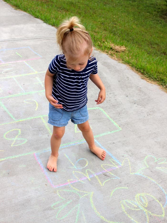 A small kid playing hopscotch in the garden