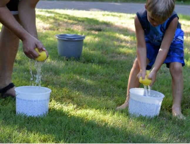 Kids playing fill the bucket game outdoors