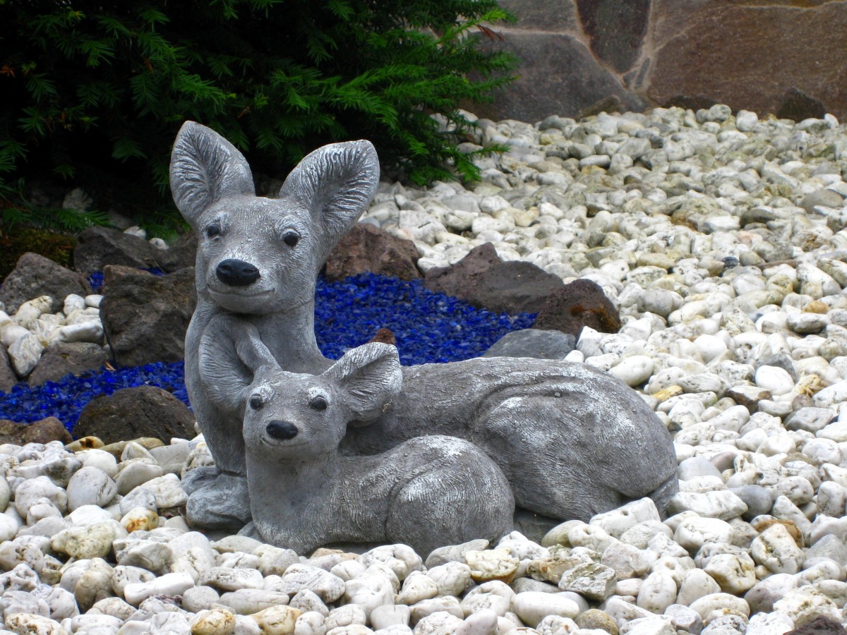 Pebble landscape with stone deer statues