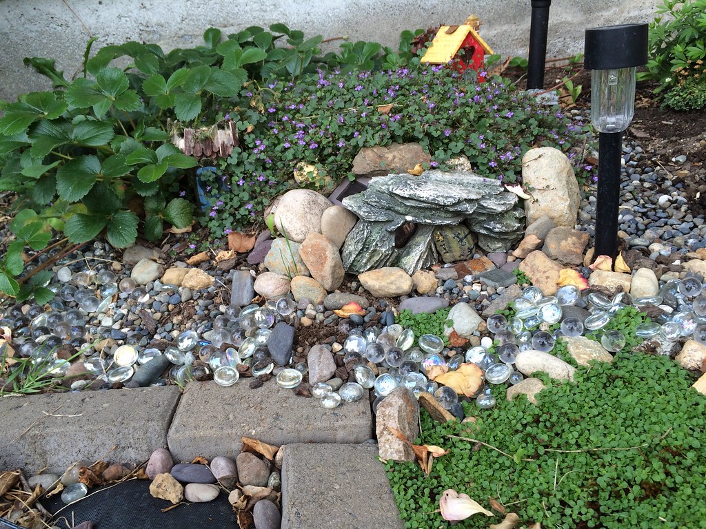 Pebble and gravel garden corner with solar-powered LED stake
