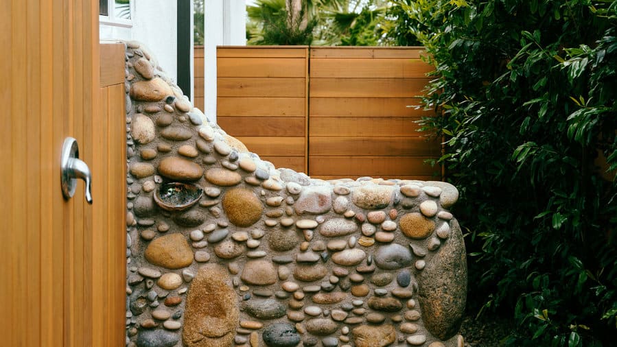 Cobble-embellished wall outdoor shower