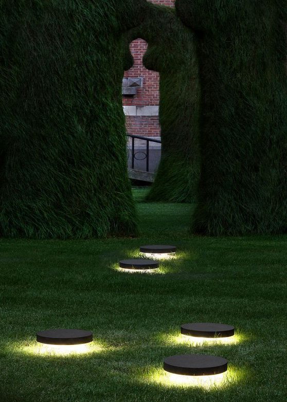 Massive arch hedges with recessed floor light fixture
