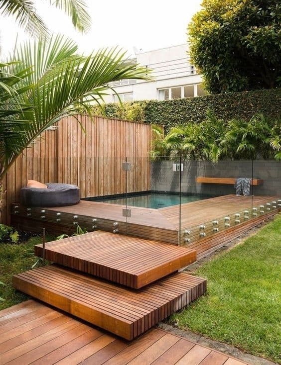 Mini pool enclosed with a wooden deck and a transparent glass wall