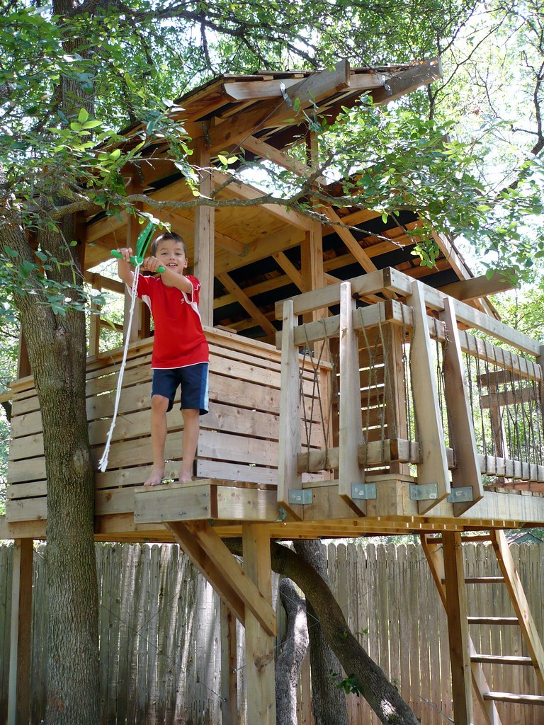 A kid on a treehouse preparing to zipline