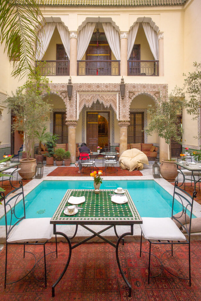 Moroccan hotel with a view of the pool lined with palm trees