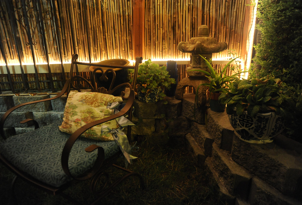 Corner garden with bamboo screening lit with LED strip lights