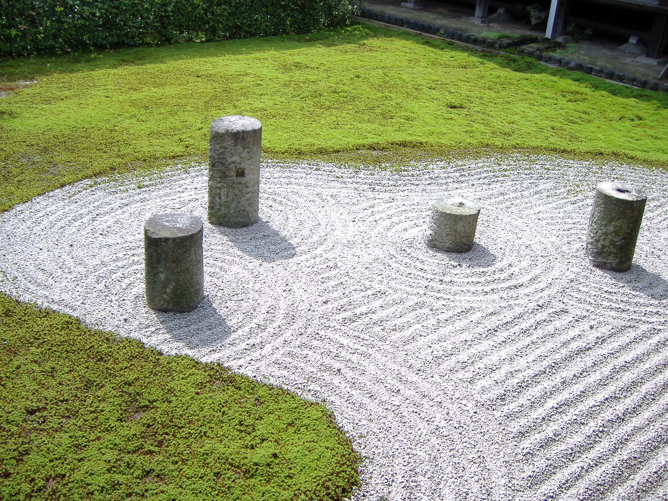 Zen garden with white sand and stone scupltures