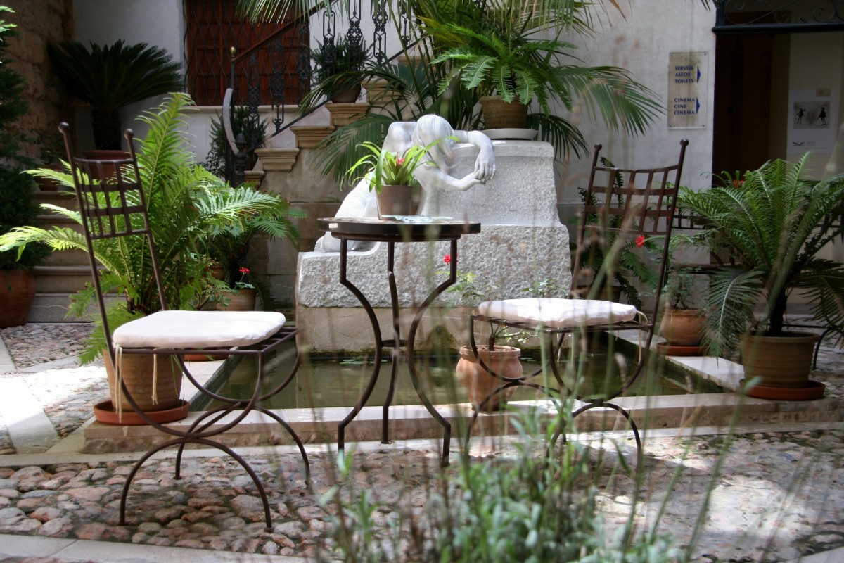 Mediterranean-inspired corner garden with cast-iron furniture