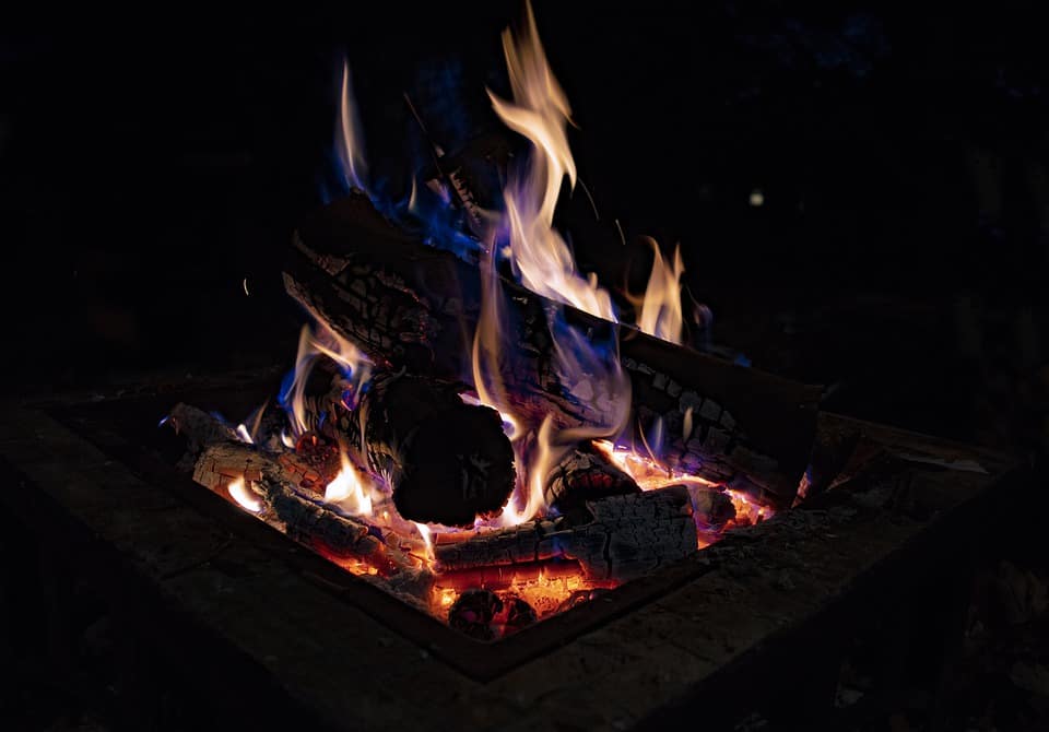 Well-lit DIY garden fire pit with firewoods