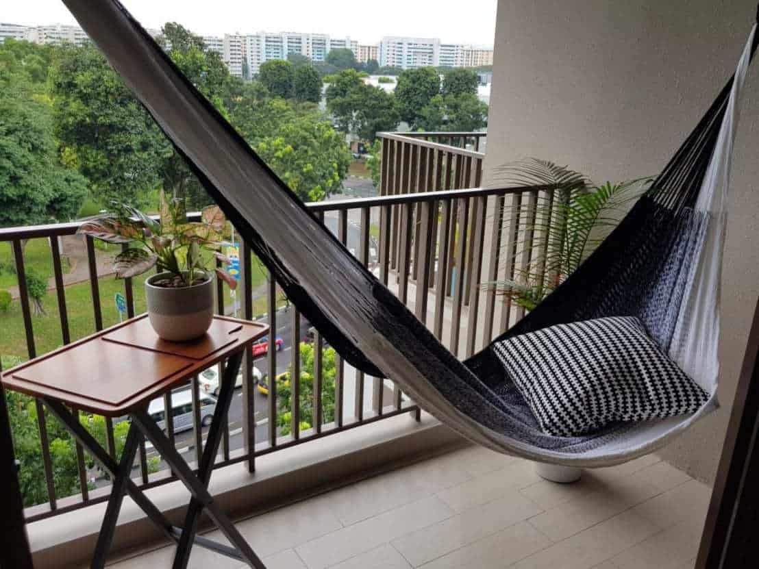 A hammock and foldable table in a small balcony space