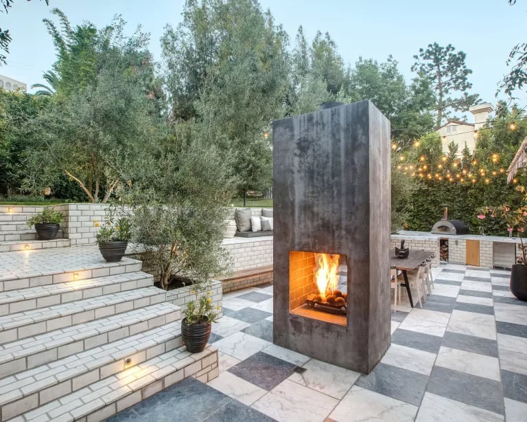 A monolithic fire pit as the focal point of this tiered garden