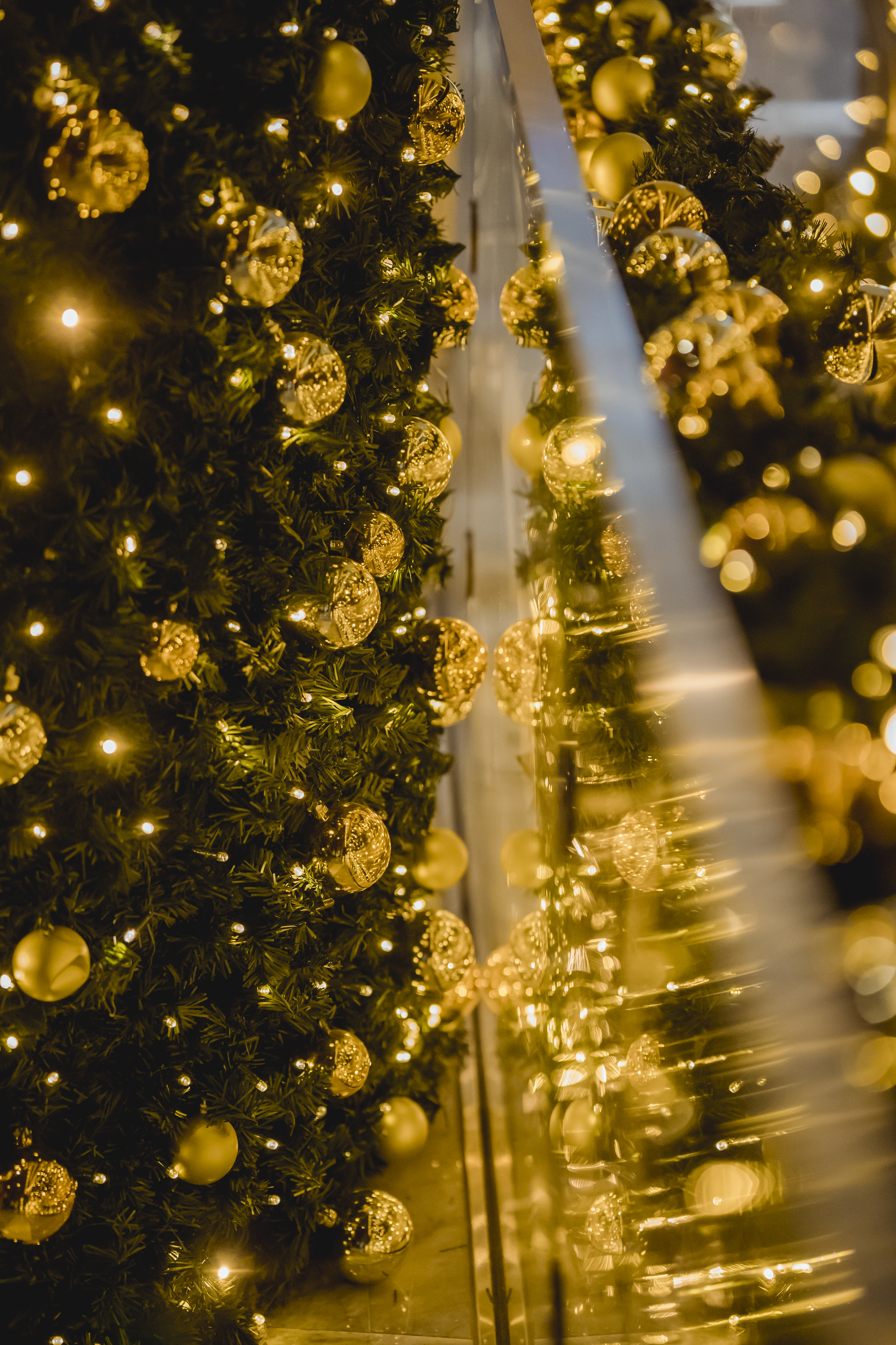 Shiny golden baubles and garland hanging on Christmas tree