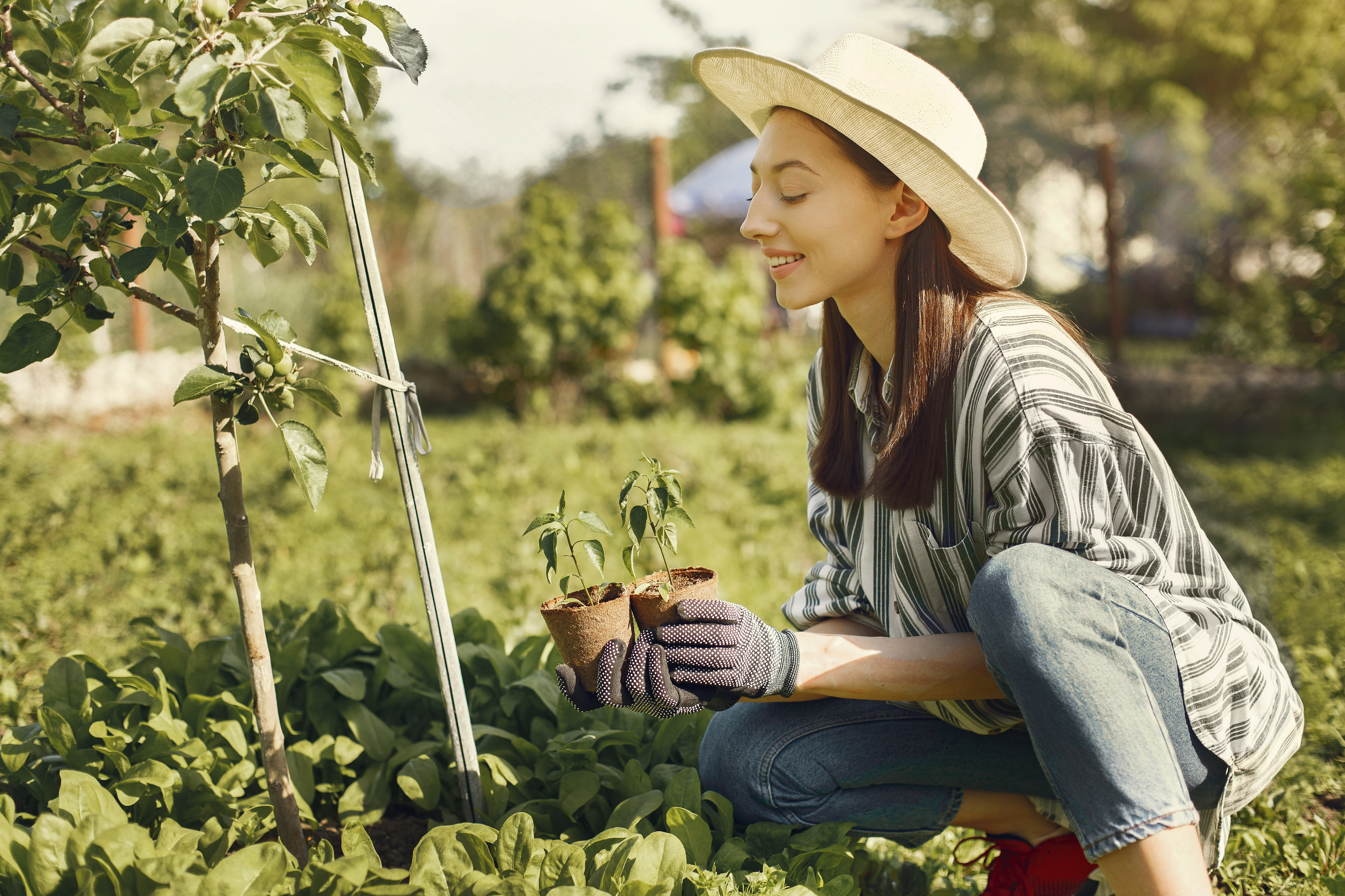 Woman in denim jeans and hat gardening