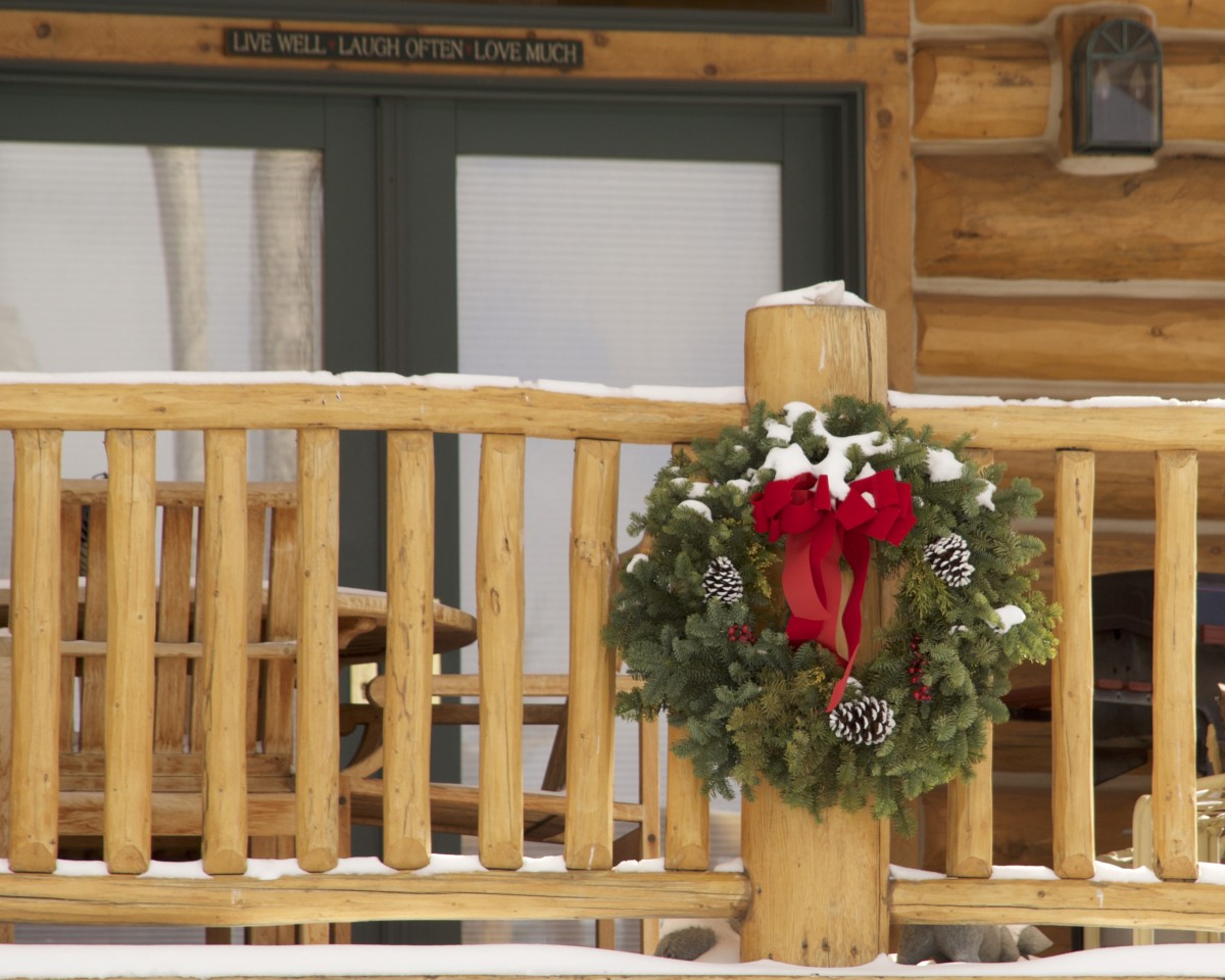 Christmas wreath on a cabin porch railing