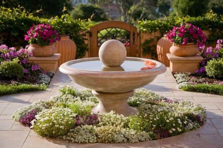 Mediterranean fountain concept with flower bed 