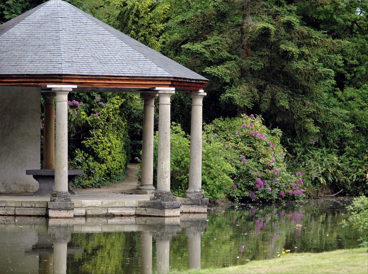 Ancient gazebo on a nearby man-made pond and surrounded with trees and greenery