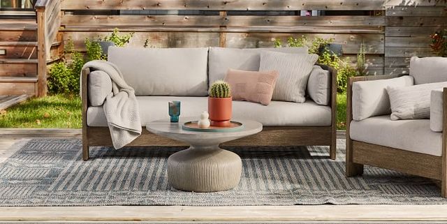 A simple patio setup with furniture decorated with a rug and blanket