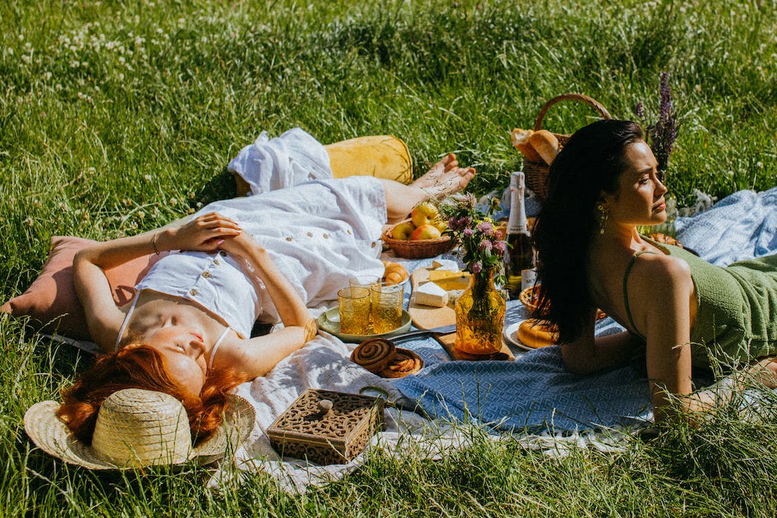 Two girl lying on a picnic blanket