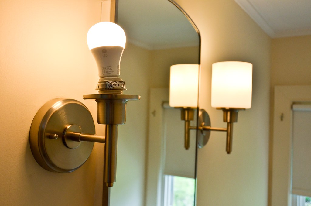 Wall scones lamp in between a wall mirror
