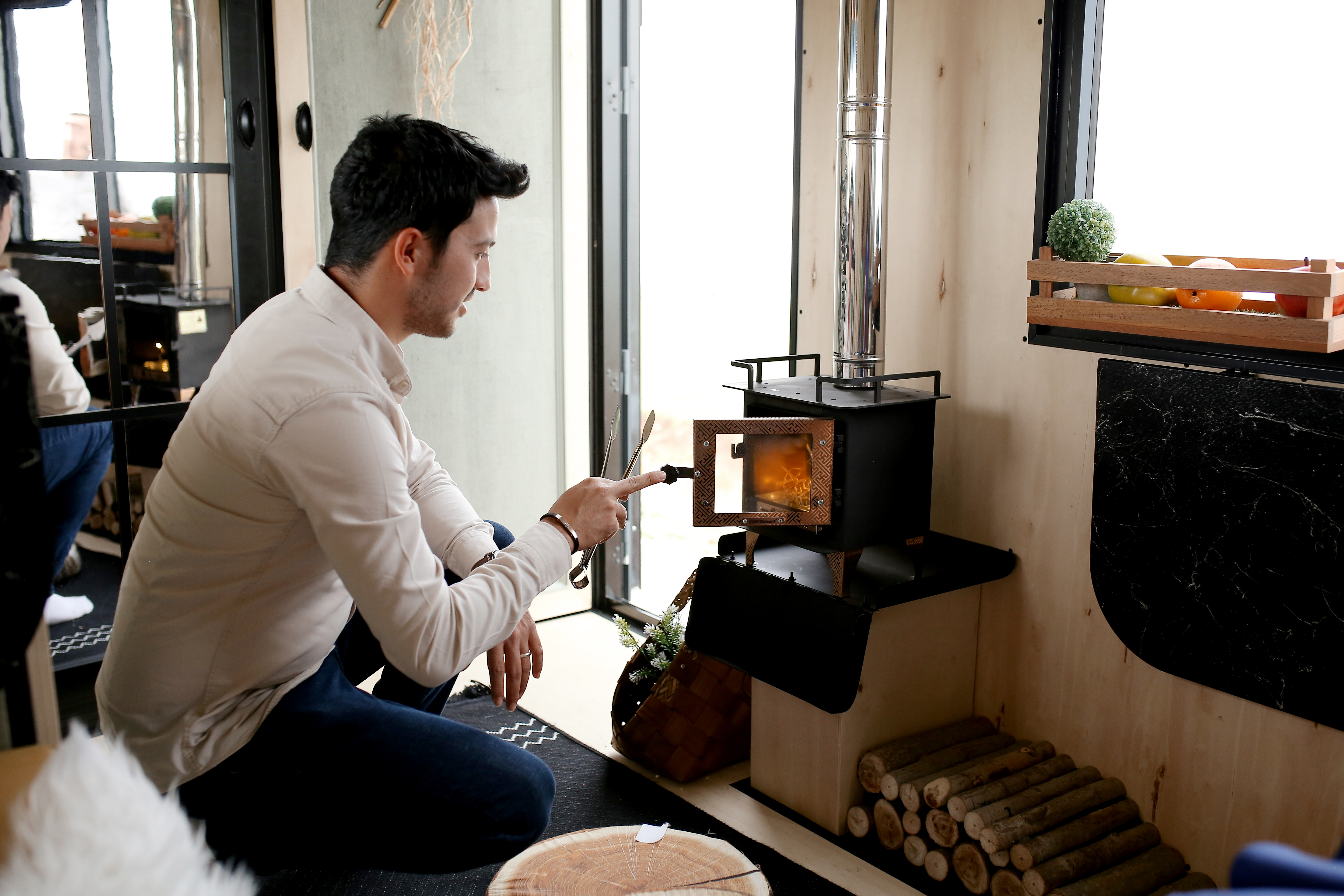 A man managing a small pizza oven indoor chiminea